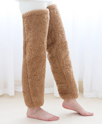 Brown fuzzy leg warmers worn by a person on a white background